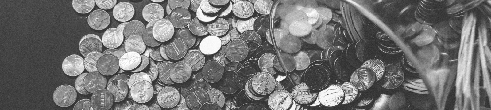 Jar with coins spread out on a table