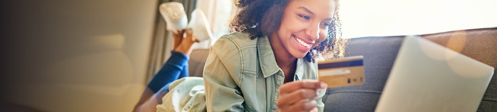 Woman holding a credit card looking at a laptop screen