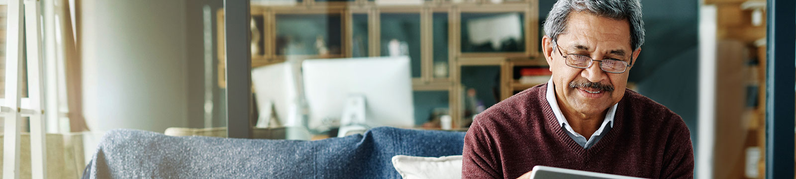 Mature man using tablet at home.