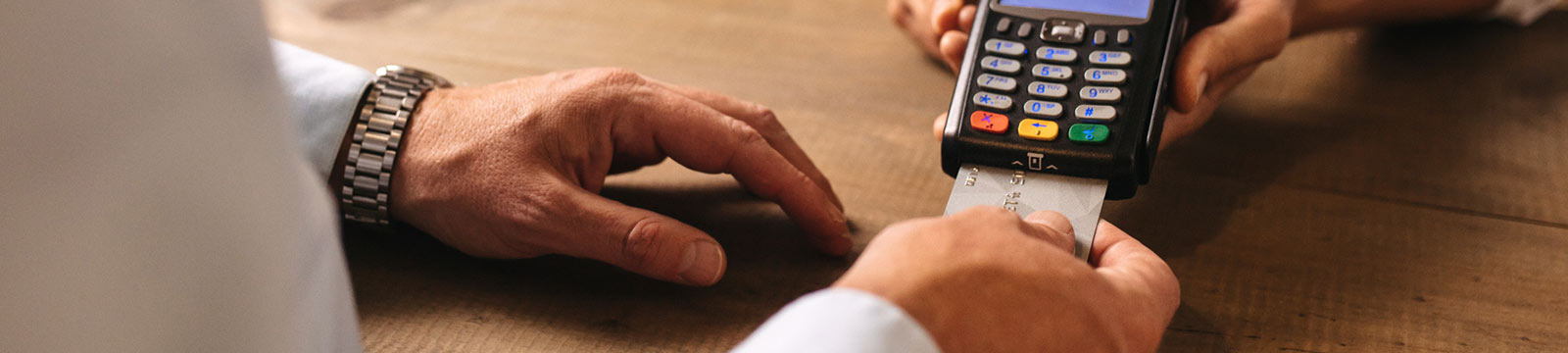 Man paying with card using credit card reader.