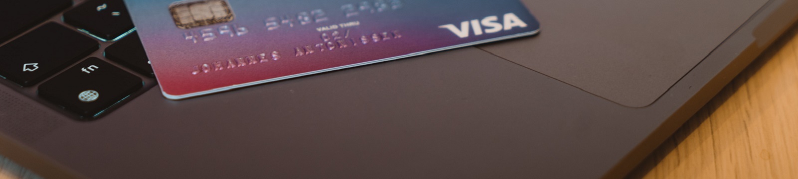 Visa credit card laying on laptop computer